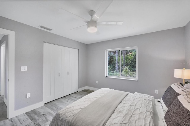 bedroom with ceiling fan, a closet, and light hardwood / wood-style floors