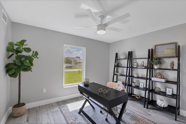 home office with light hardwood / wood-style flooring and ceiling fan