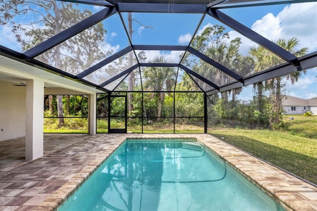 view of swimming pool featuring a yard, a patio, and a lanai