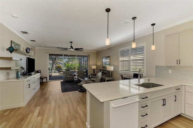 kitchen with pendant lighting, dishwasher, white cabinets, sink, and kitchen peninsula