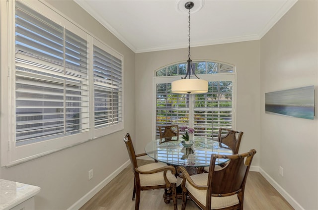 dining space featuring crown molding and light hardwood / wood-style floors