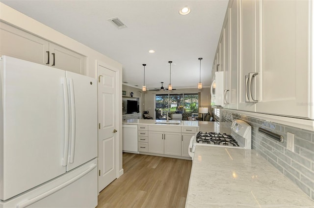 kitchen with light stone countertops, ceiling fan, hanging light fixtures, white appliances, and white cabinets