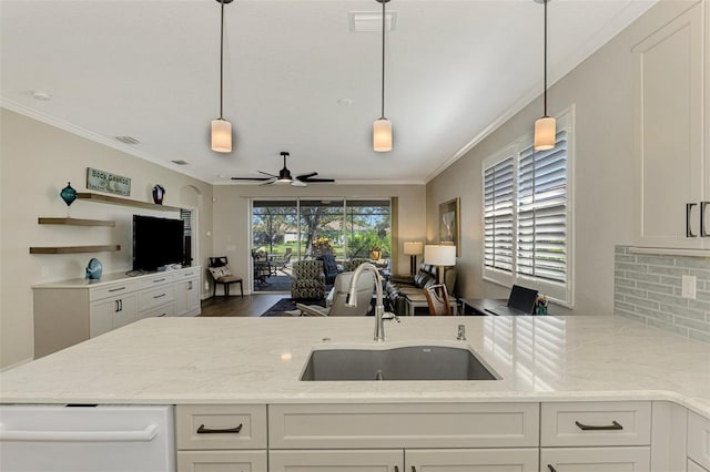 kitchen with light stone countertops, pendant lighting, white cabinets, and sink