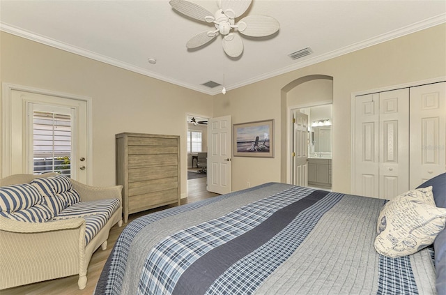 bedroom with connected bathroom, ceiling fan, crown molding, hardwood / wood-style floors, and a closet