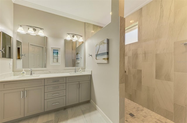 bathroom with a tile shower, vanity, and ornamental molding