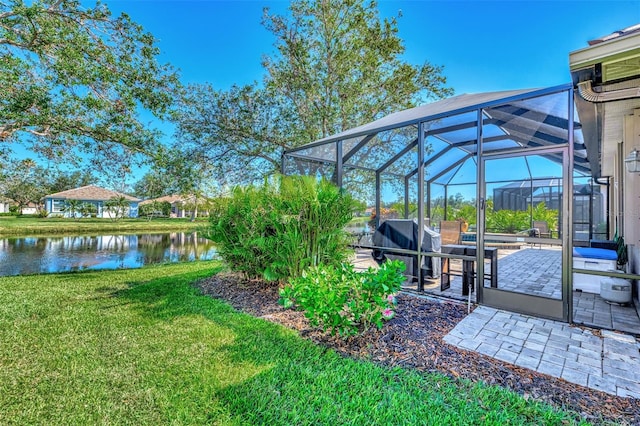 view of yard with a patio area, a lanai, and a water view