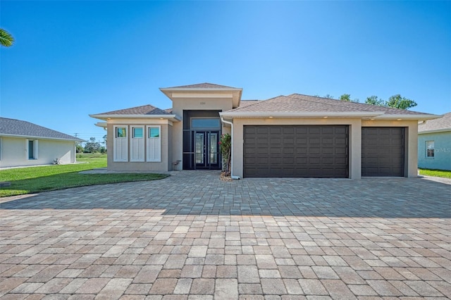 prairie-style home featuring a garage and a front lawn