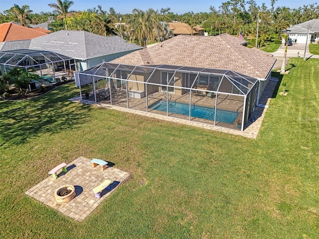 exterior space featuring a fire pit, glass enclosure, a patio, and a lawn