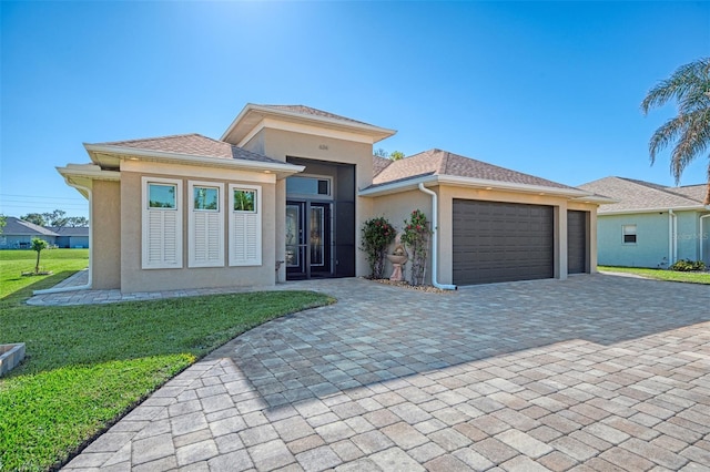 prairie-style house featuring a garage and a front lawn