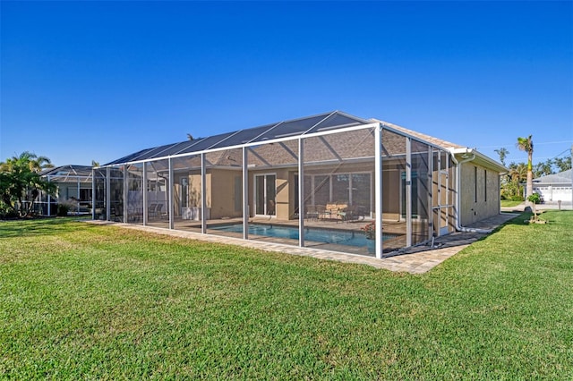 back of property with glass enclosure and a yard