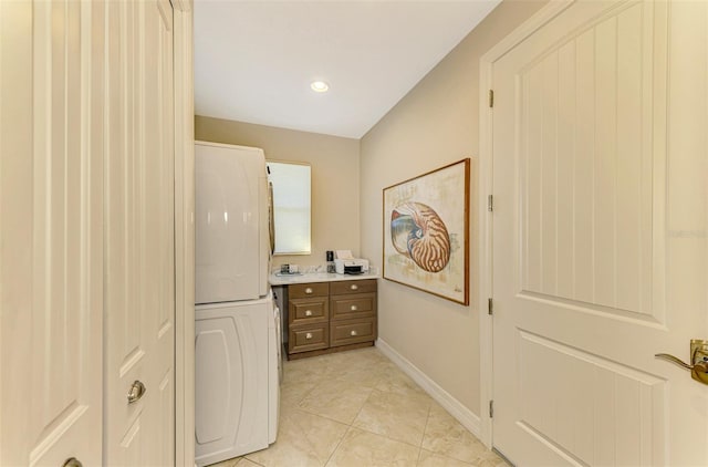 bathroom featuring tile patterned floors and stacked washer and clothes dryer