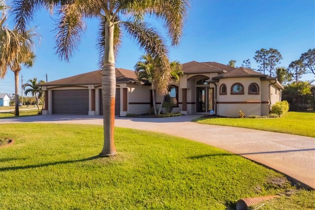 2 Marker Rd, Rotonda West, FL 33947 - mediterranean / spanish home featuring stucco siding, driveway, a front lawn, and a garage