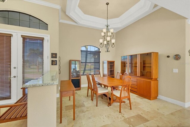 2 Marker Rd, Rotonda West, FL 33947 - dining area with ornamental molding, baseboards, a high ceiling, a chandelier, and a raised ceiling