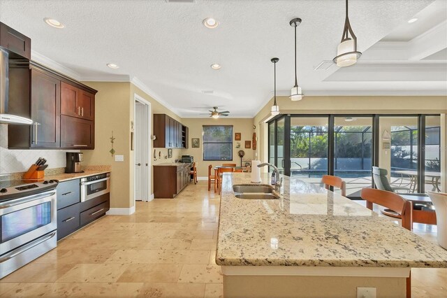 2 Marker Rd, Rotonda West, FL 33947 - kitchen featuring stainless steel appliances, a sink, ornamental molding, a center island with sink, and a ceiling fan