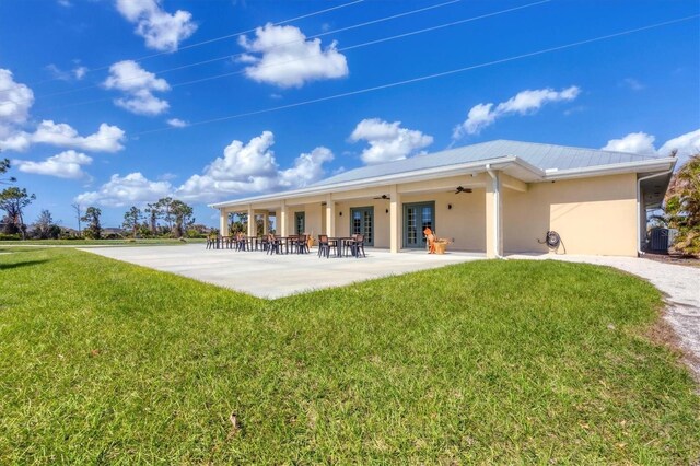 2 Marker Rd, Rotonda West, FL 33947 - back of house with ceiling fan, stucco siding, a yard, metal roof, and a patio area