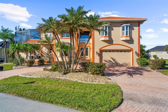 mediterranean / spanish-style home featuring a lanai, a garage, and a front yard