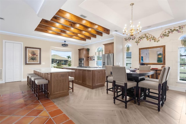 dining space with a tray ceiling, a healthy amount of sunlight, and an inviting chandelier