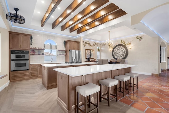 kitchen featuring a large island, a breakfast bar, pendant lighting, and appliances with stainless steel finishes