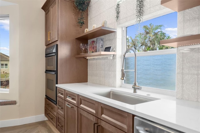 kitchen with appliances with stainless steel finishes, a water view, a wealth of natural light, and sink