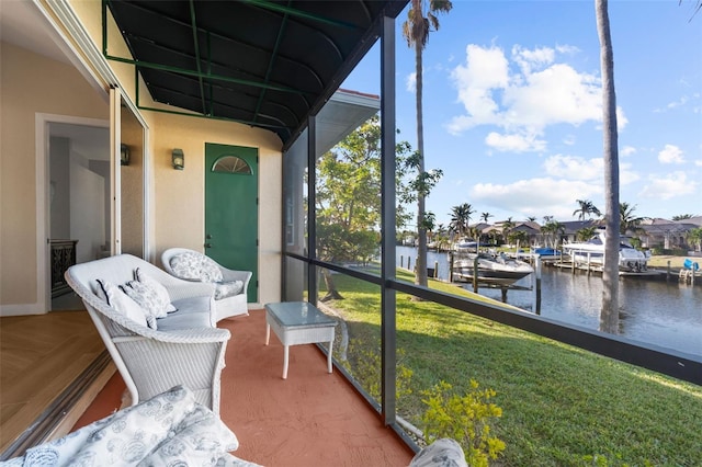 sunroom featuring a water view