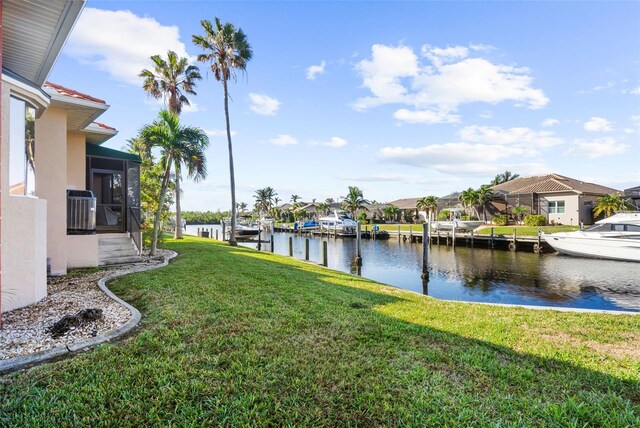 view of yard featuring a sunroom, a water view, and central AC