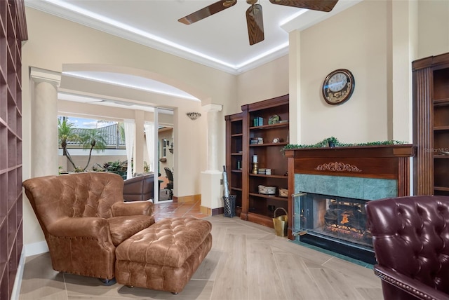 living area featuring ceiling fan, a fireplace, light parquet flooring, and ornamental molding