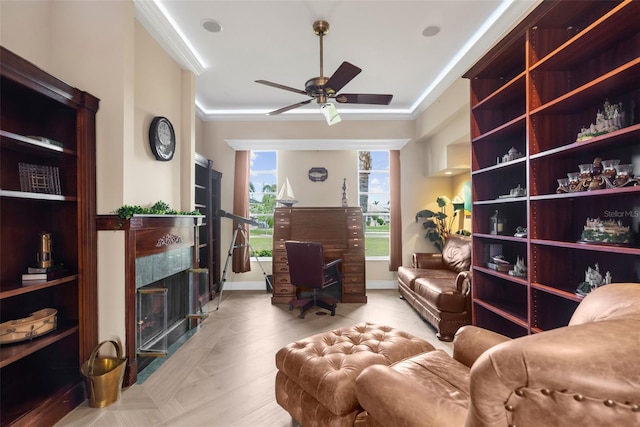 living area with ceiling fan and ornamental molding