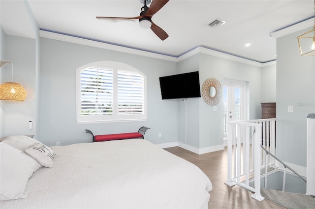 bedroom featuring hardwood / wood-style flooring, ceiling fan, and crown molding