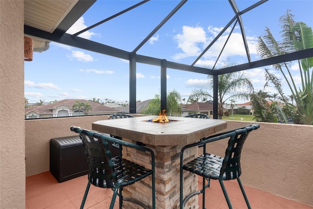 view of patio with a lanai, a bar, and a fire pit