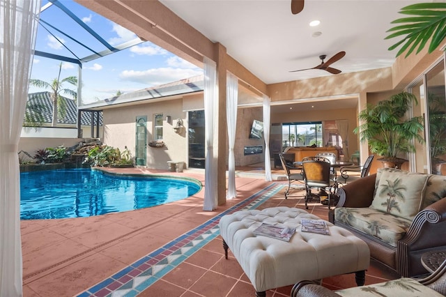 view of swimming pool with a patio area, ceiling fan, glass enclosure, and an outdoor hangout area