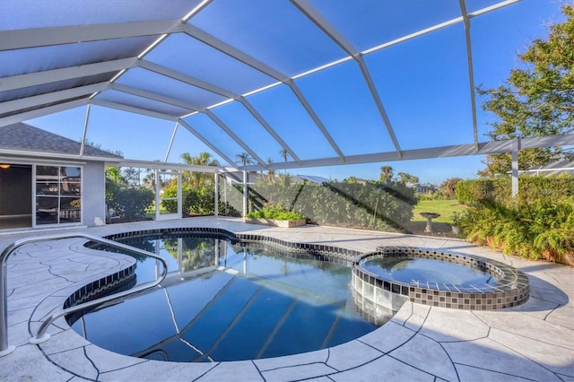 view of pool with glass enclosure, an in ground hot tub, and a patio