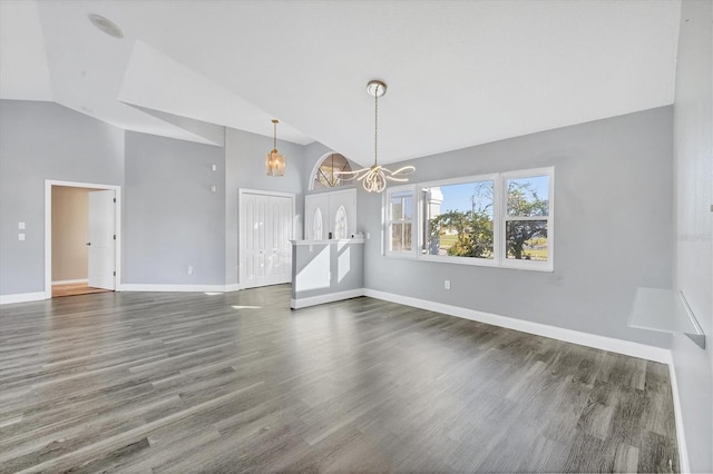 interior space with dark wood-type flooring, an inviting chandelier, and lofted ceiling