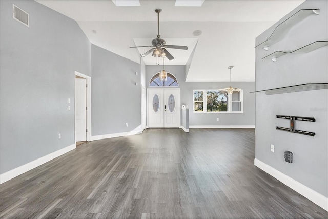 unfurnished living room featuring dark hardwood / wood-style flooring, vaulted ceiling, and ceiling fan