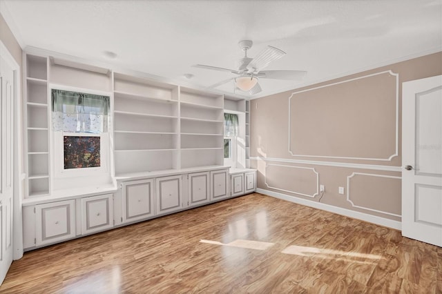 empty room with ceiling fan, light wood-type flooring, and crown molding