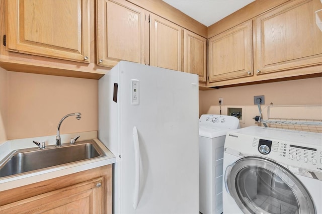 washroom featuring washer and clothes dryer, cabinets, and sink