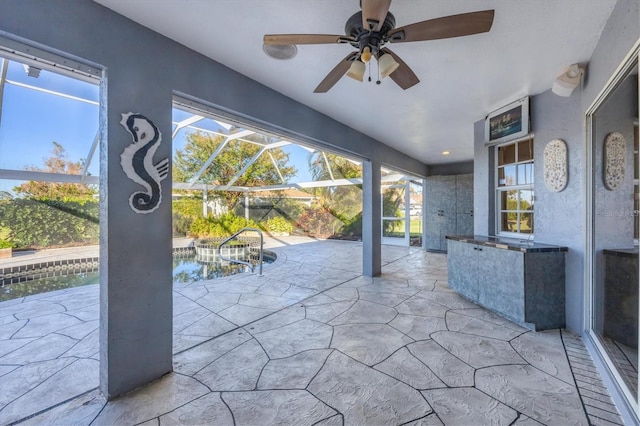 view of patio featuring a lanai and ceiling fan