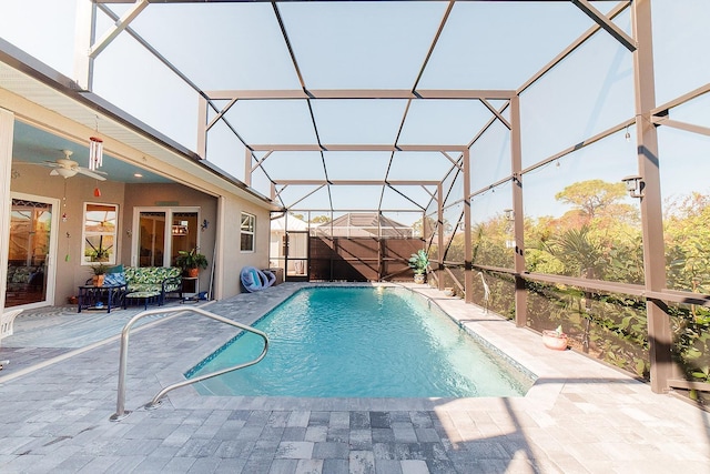 view of pool with ceiling fan, a lanai, and a patio