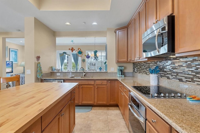 10390 Longshore Rd Unit 82, Placida, FL 33946 - kitchen featuring appliances with stainless steel finishes, tasteful backsplash, recessed lighting, light tile patterned floors, and brown cabinets