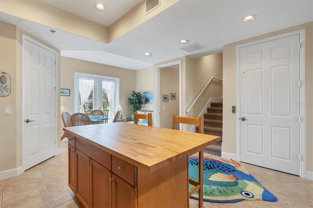 10390 Longshore Rd Unit 82, Placida, FL 33946 - kitchen featuring light tile patterned floors, a breakfast bar area, brown cabinetry, wooden counters, and recessed lighting