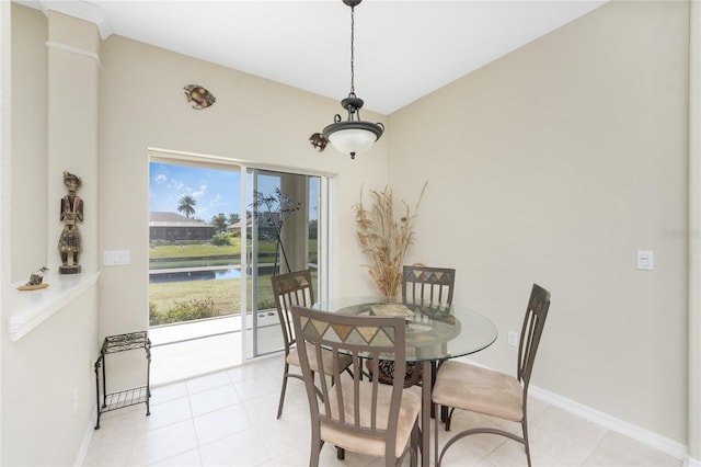 dining area featuring a water view and light tile patterned floors