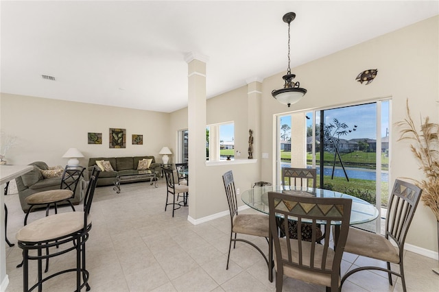 dining space with a healthy amount of sunlight, light tile patterned flooring, and decorative columns