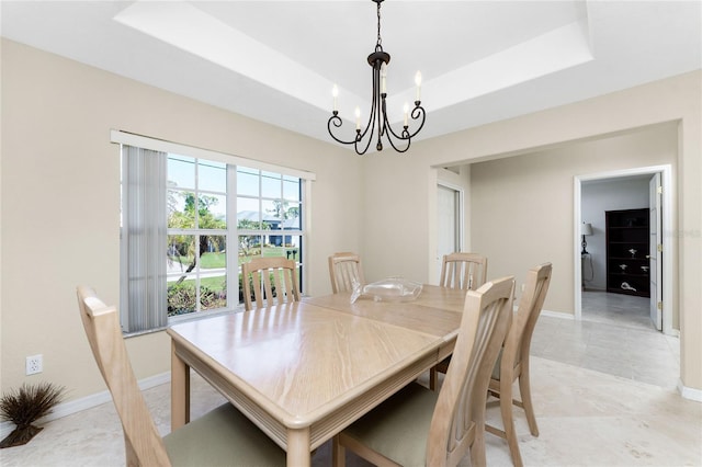 dining room with a raised ceiling and an inviting chandelier