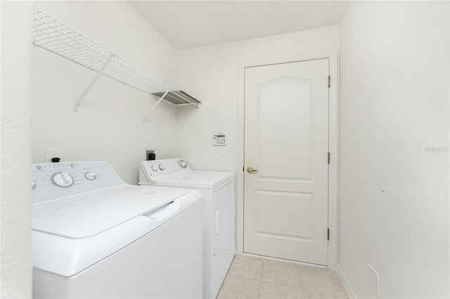 washroom with light tile patterned floors and washer and clothes dryer