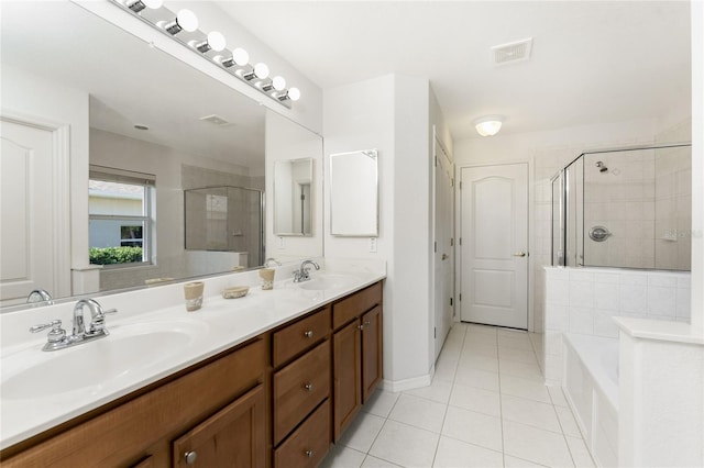 bathroom featuring plus walk in shower, vanity, and tile patterned floors