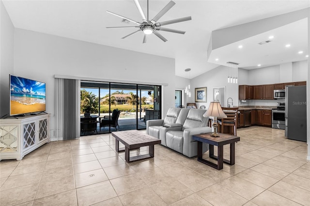 living room featuring sink, ceiling fan with notable chandelier, high vaulted ceiling, and light tile patterned flooring