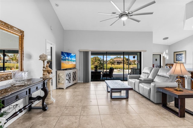 living room featuring light tile patterned floors, ceiling fan with notable chandelier, and high vaulted ceiling