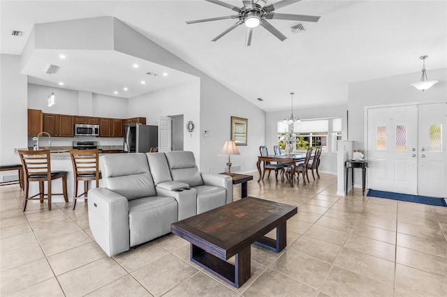 tiled living room with high vaulted ceiling and ceiling fan with notable chandelier