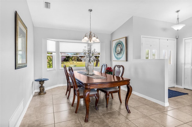 tiled dining area with lofted ceiling and a notable chandelier