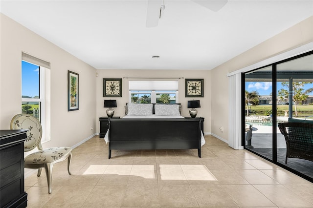 tiled bedroom featuring ceiling fan, access to outside, and multiple windows