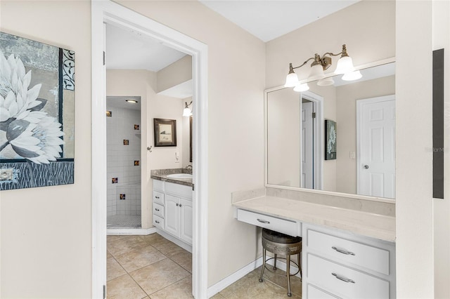 bathroom with tile patterned flooring, a tile shower, and vanity